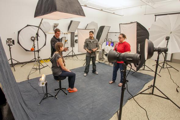 photography students in studio with cameras and lights