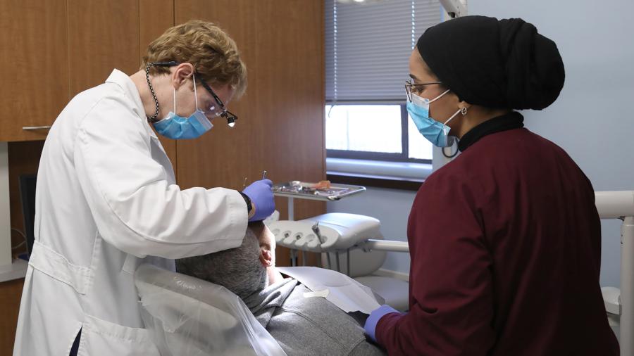 牙医和助手正在清洁社区病人的牙齿