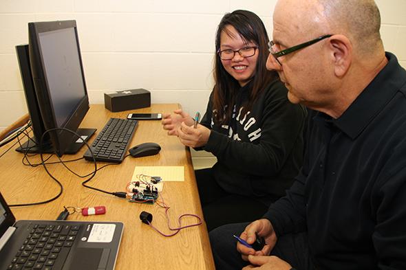 professor and student at computer with information technology hardware